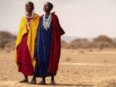 Zwei Frauen in der Steppe in traditionellen Kostümen.